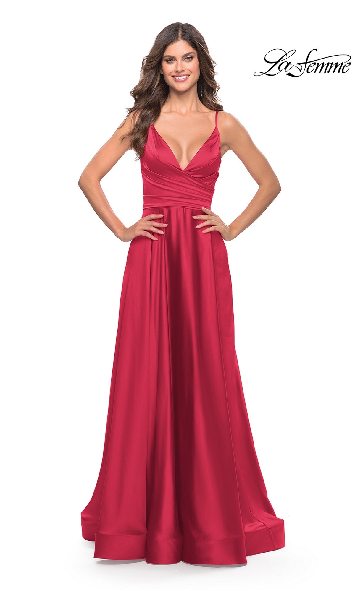 A woman stands with hands on hips, wearing the La Femme V-Neck Long A-Line Prom Dress 28607—a sleeveless, floor-length red satin gown with a fitted bodice and flared skirt. The La Femme 28607 logo is shown in the top right corner.